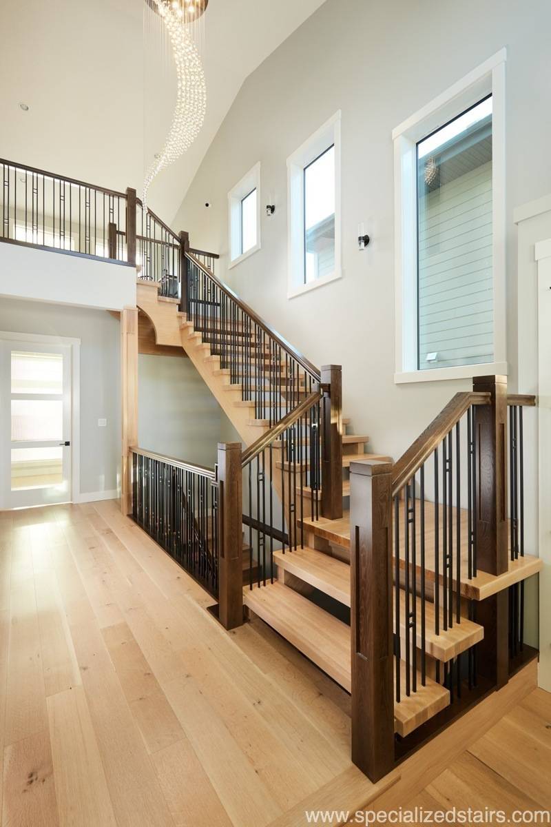 A two toned, open rise white oak staircase with craftsman style newel posts and spindles.